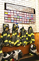 Firemen's jackets underneath a quilt made by school children. Remembering 9=11.